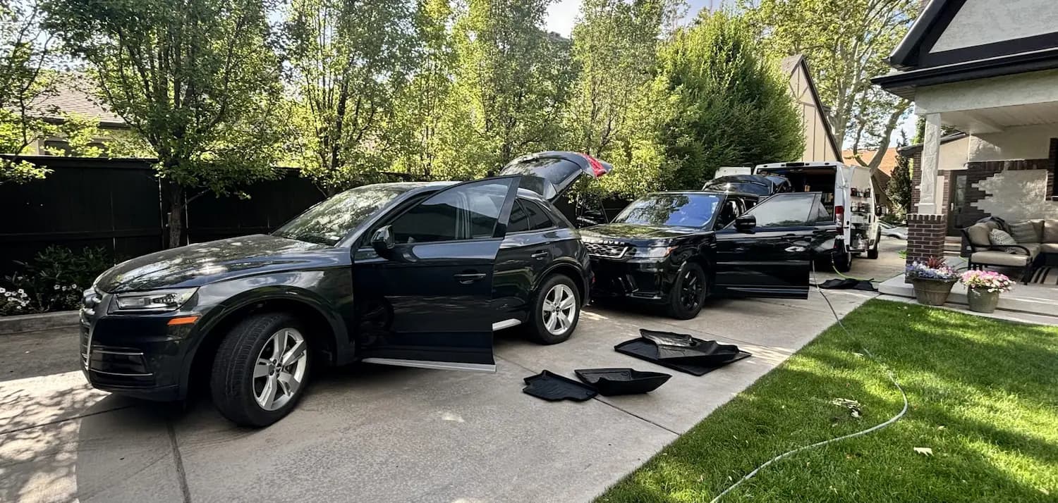 Two SUVs being detailed in a residential driveway